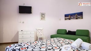 A bedroom with a bed, a dresser, a chair, a TV, and a painting of a bridge. - Zobeide - Next stop Colosseum (Rome)