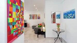 A modern living room with a sofa, a coffee table, and a painting on the wall. - Maison Roberta (Rome)