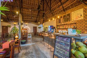 A cozy restaurant with a rustic interior, featuring a brick wall, wooden furniture, and a chalkboard menu.