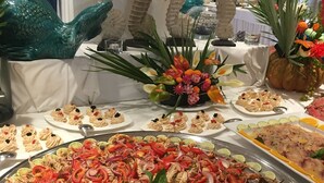 A buffet with seafood dishes, decorative wall art, and a variety of table settings. - Cala Rosa Club Hotel (Stintino)
