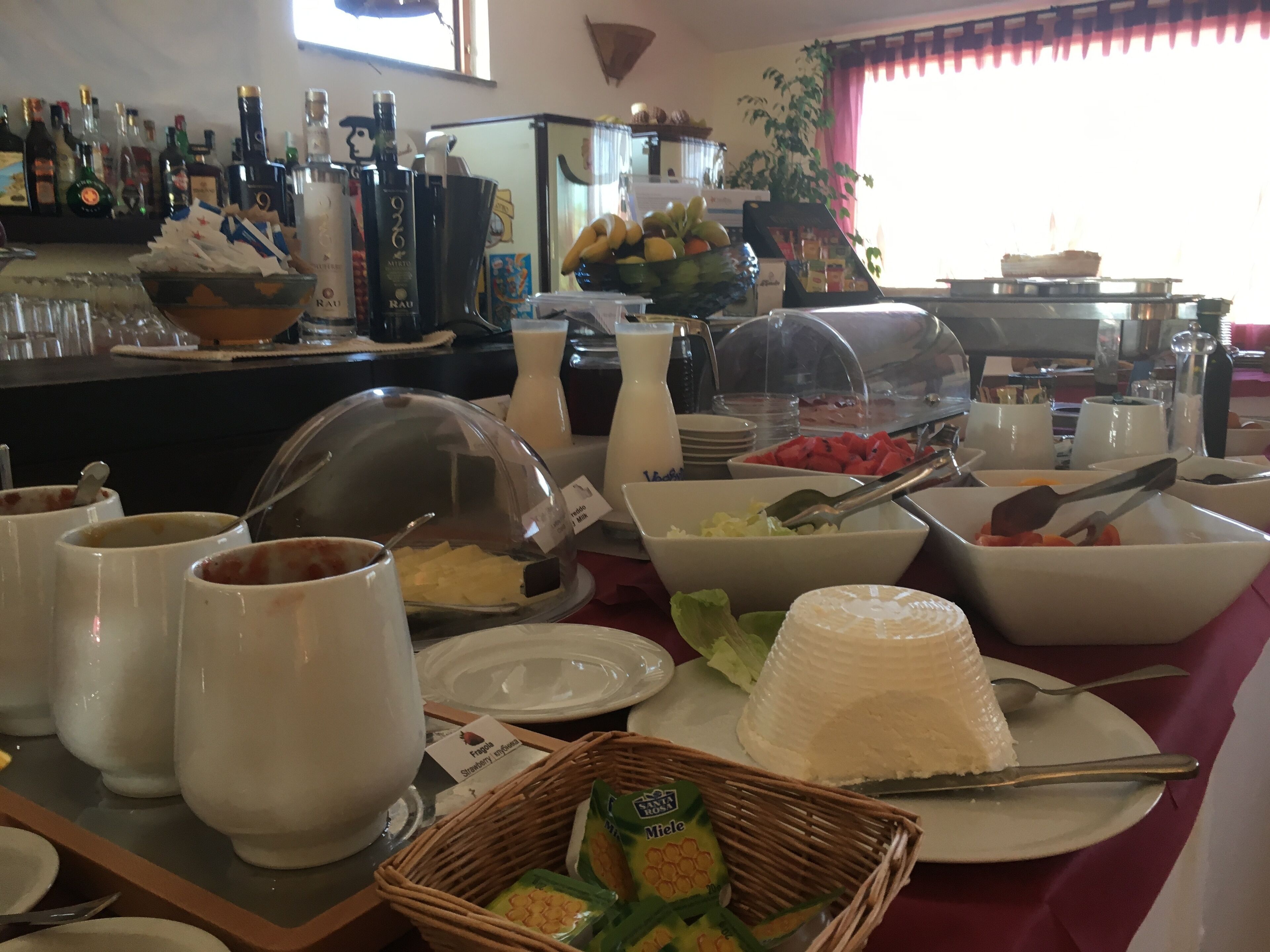 A buffet setup with various food items, including fruits, salads, and beverages.