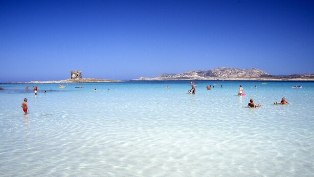 A clear blue sea with people swimming and sunbathing. - Cala Rosa Club Hotel (Stintino)