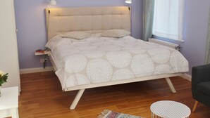A neatly arranged bedroom with a bed, bedside tables, and a chair. - Nice apartment lilac central (Bremen)