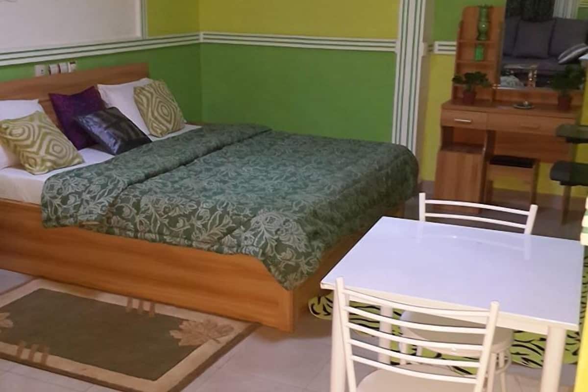 A room with a bed, a desk, and a chair.