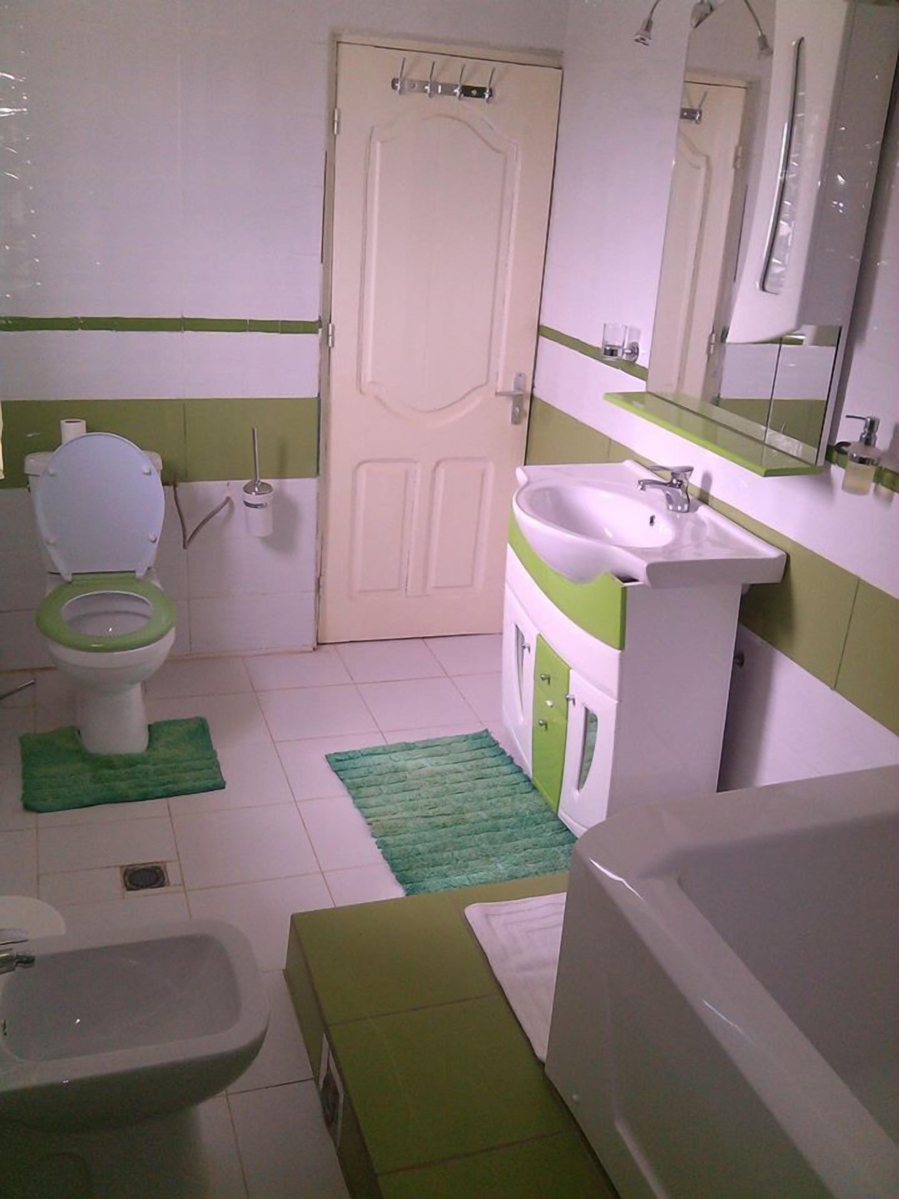 Ein Badezimmer mit Toilette, Bidet, Waschbecken und Badewanne.