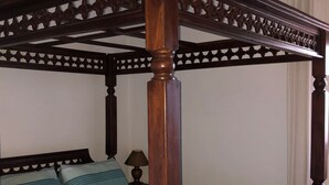 A four-poster bed with a striped bedspread, a wooden headboard, and a ceiling light fixture. - Countryside house with private pool - 6km to Vejer and 15mins from beaches

 (Vejer de la Frontera)