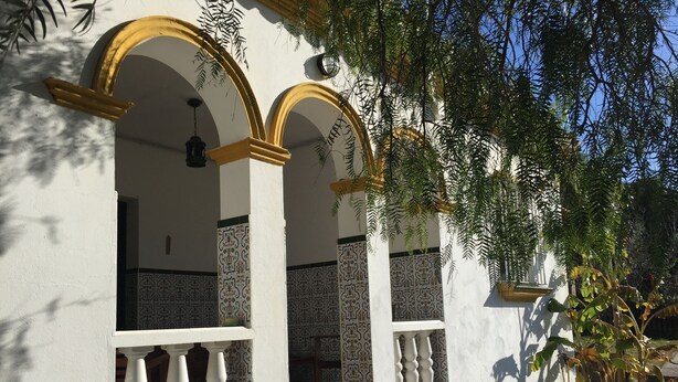 A building with white walls and yellow arches, featuring patterned tiles and a balcony with white balustrades. - Countryside house with private pool - 6km to Vejer and 15mins from beaches

 (Vejer de la Frontera)
