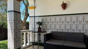 A patio with a wicker sofa, a small table, and a potted plant. - Countryside house with private pool - 6km to Vejer and 15mins from beaches

 (Vejer de la Frontera)
