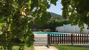 A pathway leading to a pool area with a wooden fence and lush greenery. - Countryside house with private pool - 6km to Vejer and 15mins from beaches

 (Vejer de la Frontera)