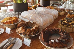 A buffet table with various food items, including cakes and pastries, and a sign indicating a specific dish.