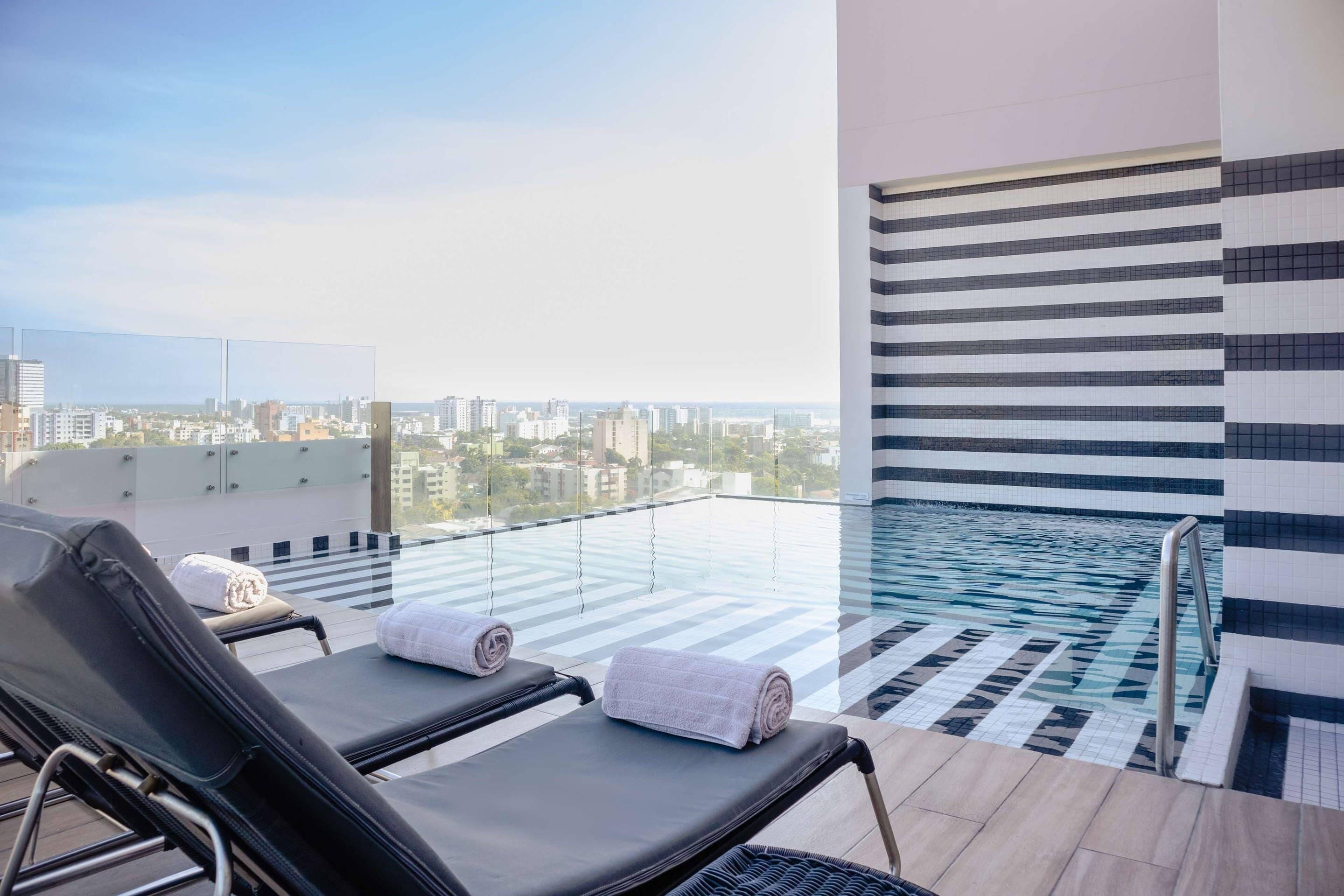 Una piscina al aire libre, sillones reclinables de piscina