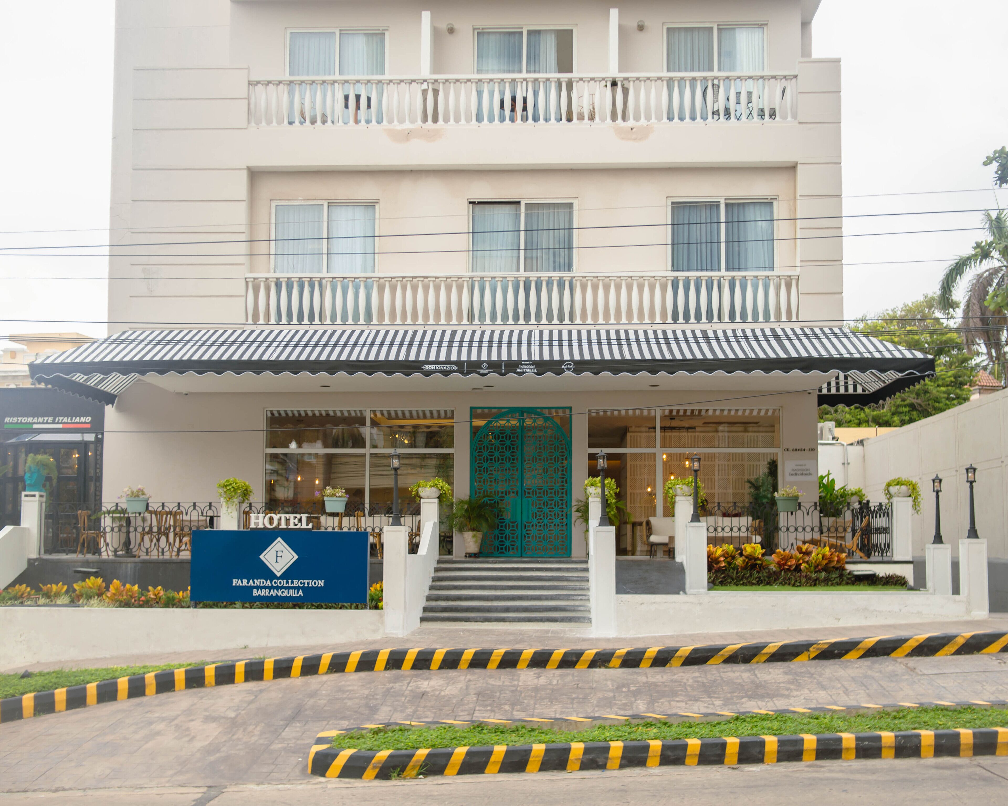 A hotel with a two-story facade, a balcony, and a sign indicating it is part of the Farandola Collection in Barra da Tijuca.