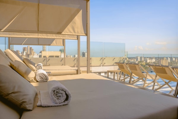 Una piscina al aire libre, sillones reclinables de piscina