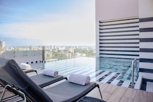 Una piscina al aire libre, sillones reclinables de piscina
