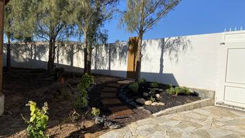 Stroll through a serene garden oasis, surrounded by lush greenery and a tranquil stone pathway.