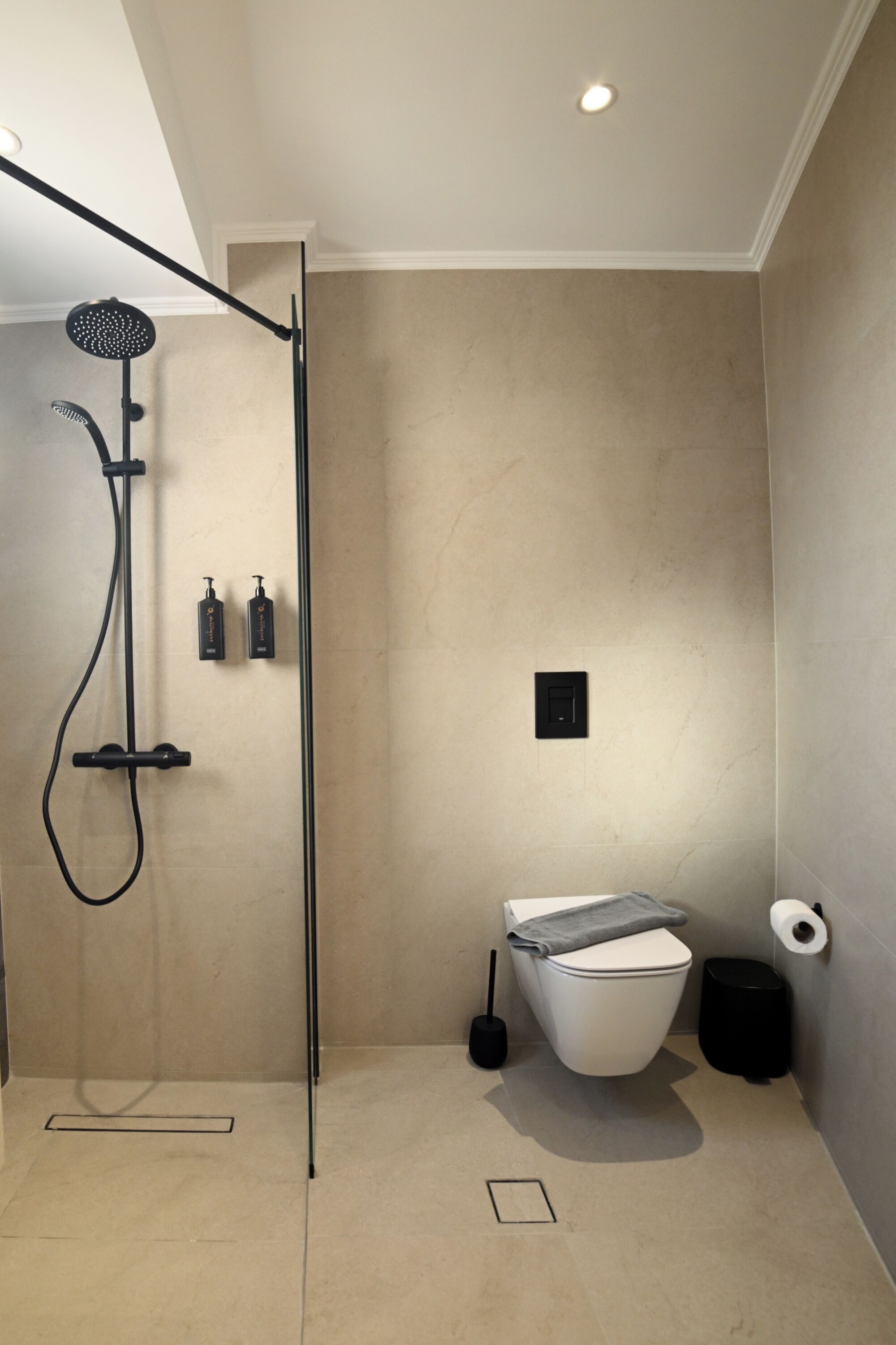 A modern bathroom with a shower, toilet, and sink.