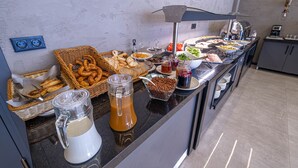A buffet setup with various food items and a coffee station. - Methis Hotel (Izmir)