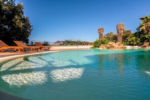 A clear swimming pool with lounge chairs and palm trees. - Oleandri 131 (Arzachena)
