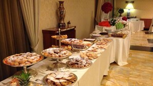 Una mesa de buffet con diversos alimentos y un jarrón decorativo.