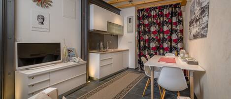 A compact living space with a kitchenette, a dining area, and a sofa.