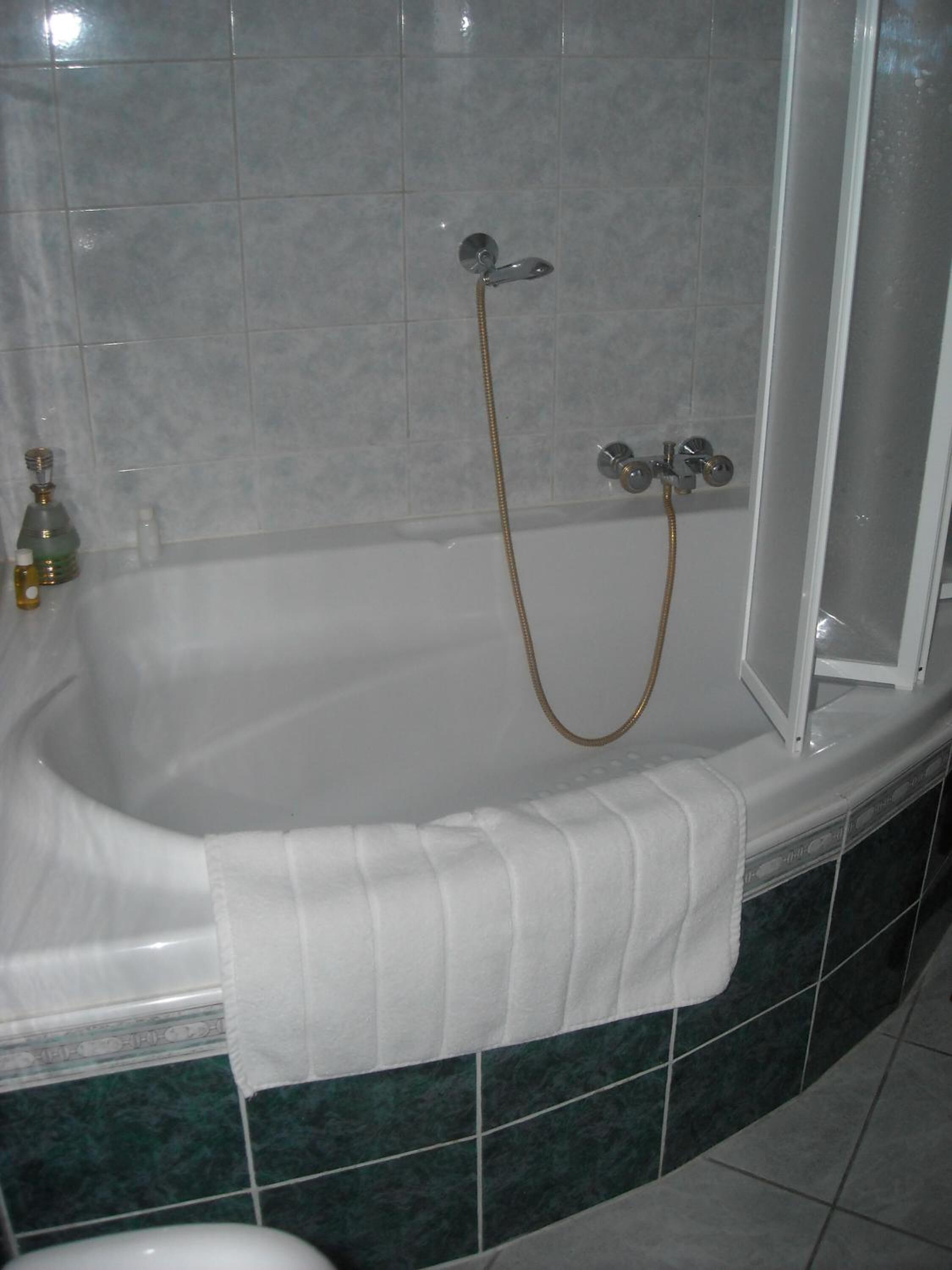A bathroom with a bathtub, a shower, and a toilet.