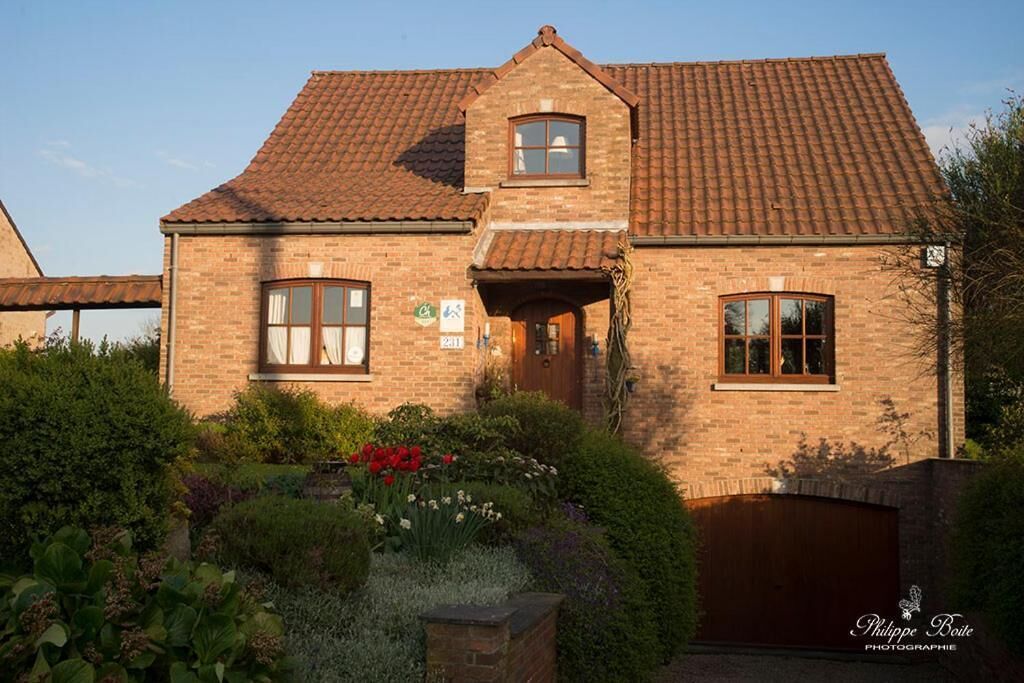 A two-story brick house with a tiled roof, a front entrance, and a garage.