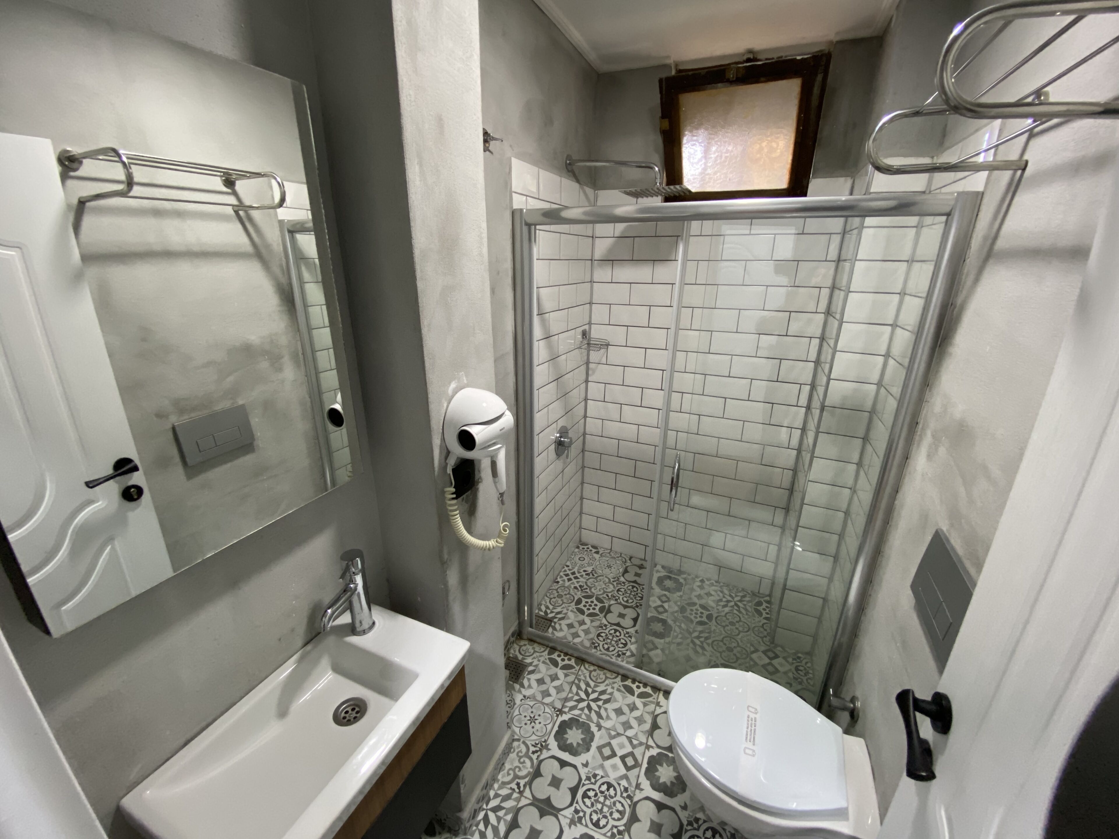 A bathroom with a sink, toilet, and a glass-enclosed shower area.