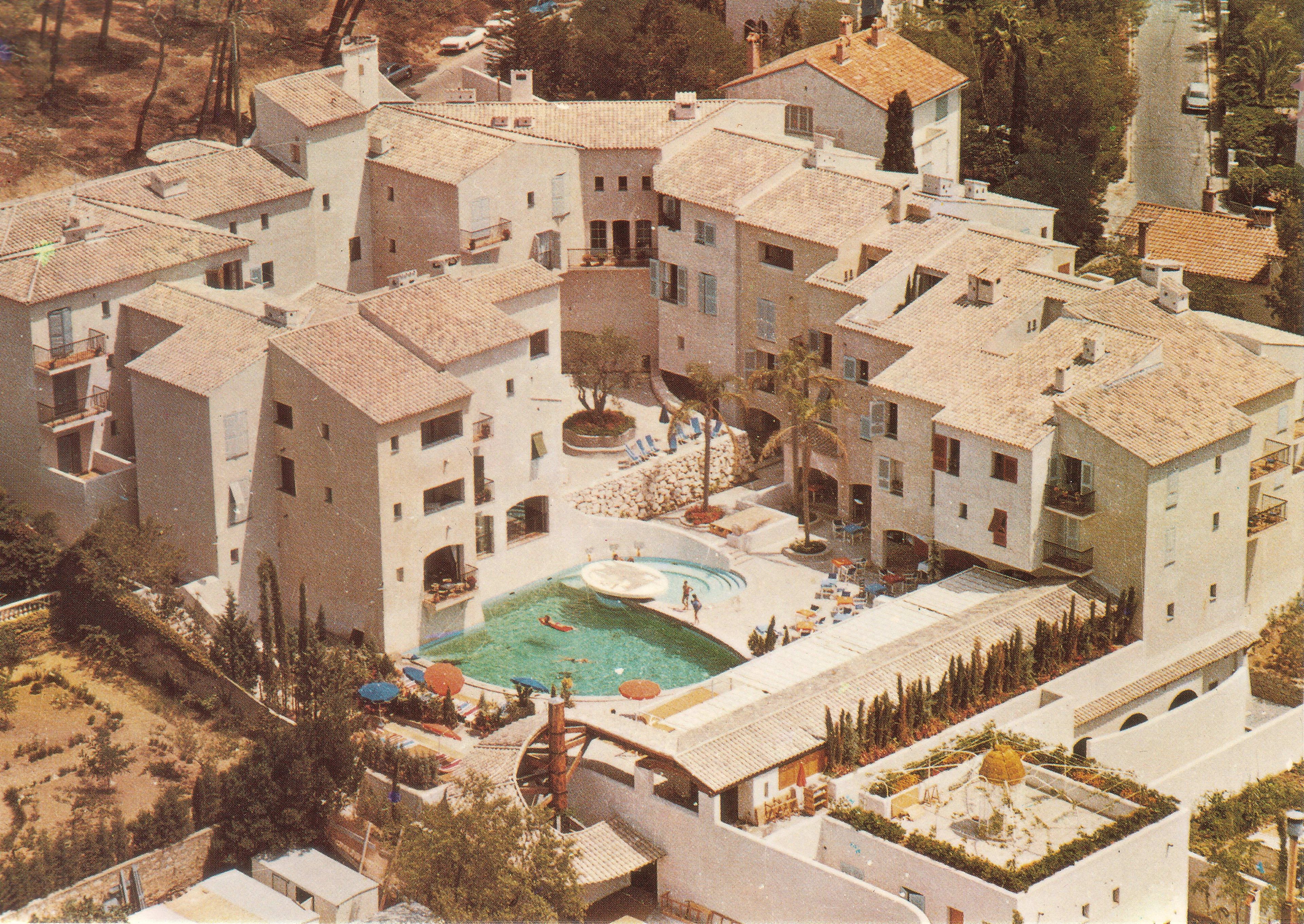 Un edificio residencial con varios balcones, piscina y un patio.