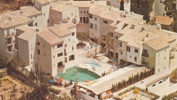 Un edificio residencial con varios balcones, piscina y un patio.