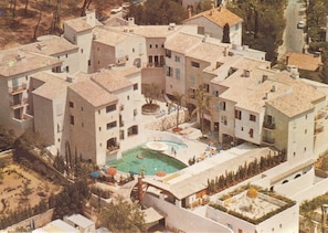 Un immeuble résidentiel doté de nombreux balcons, d’une piscine et d’une cour intérieure.