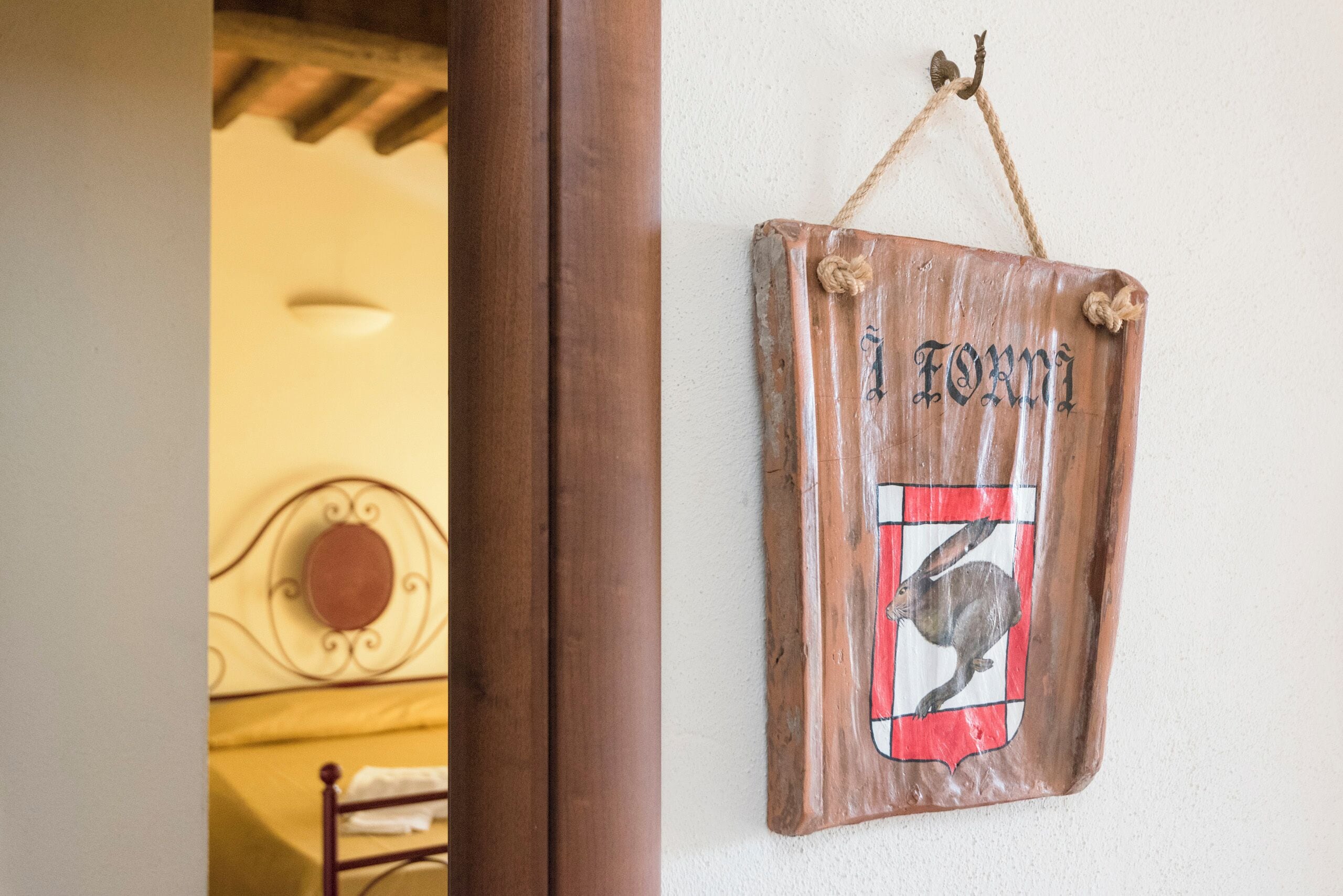 Un letrero de madera con una ilustración de un conejo y la palabra 'Formi' colgado en una pared.