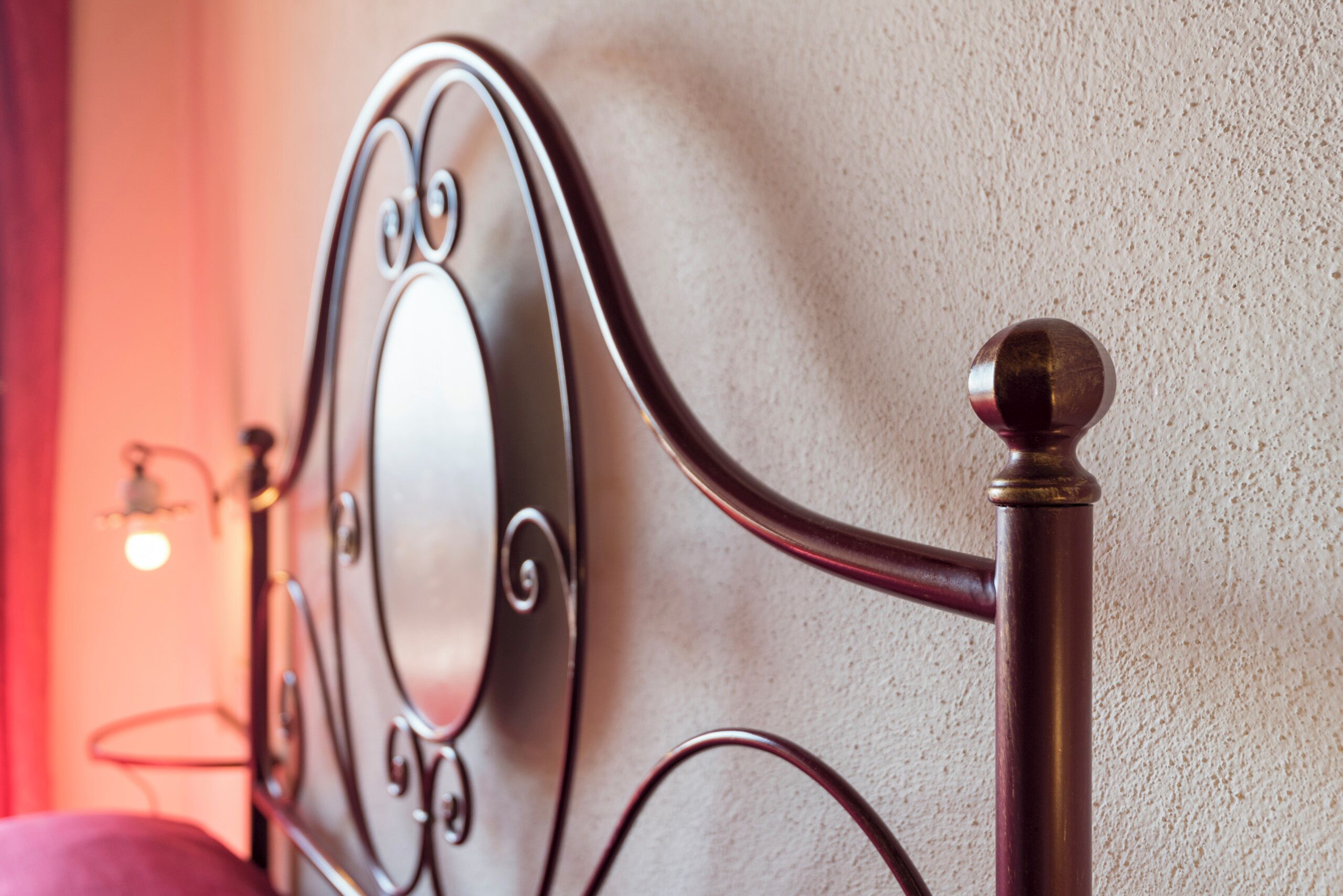 A metal bed frame with a round headboard and a decorative finial.