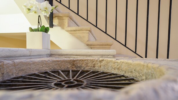 A stone staircase with a metal handrail and a drain grate at the bottom. - Arena di Verona Rensi Italianflat (Verona)