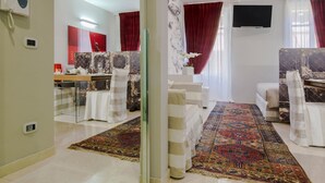 A modern living room with a sofa, a coffee table, and a TV mounted on the wall. There is a patterned rug on the floor and a red curtain on the window. - Arena di Verona Rensi Italianflat (Verona)