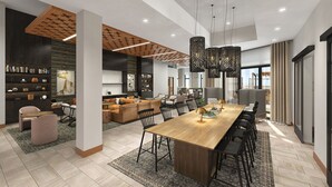Un intérieur moderne avec une grande table à manger, des canapés et un coin cuisine.