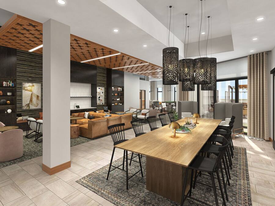 Um interior moderno com uma grande mesa de jantar, sofás e área de cozinha.