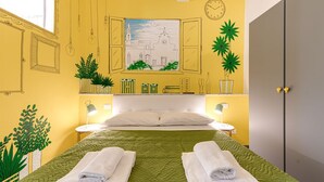 Habitación de hotel con cama, dos mesitas de noche, un reloj de pared y una ventana.
