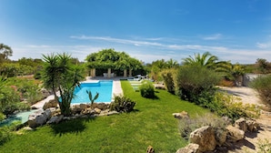 A private pool surrounded by lush greenery and rocks. - Villa Mila by Perle di Puglia (Torre Vado)