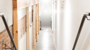 A narrow, well-lit stairway with a wooden floor leading to a higher level. - Luxury apartment with a private rooftop deck located in the heart of downtown JC (Johnson City)