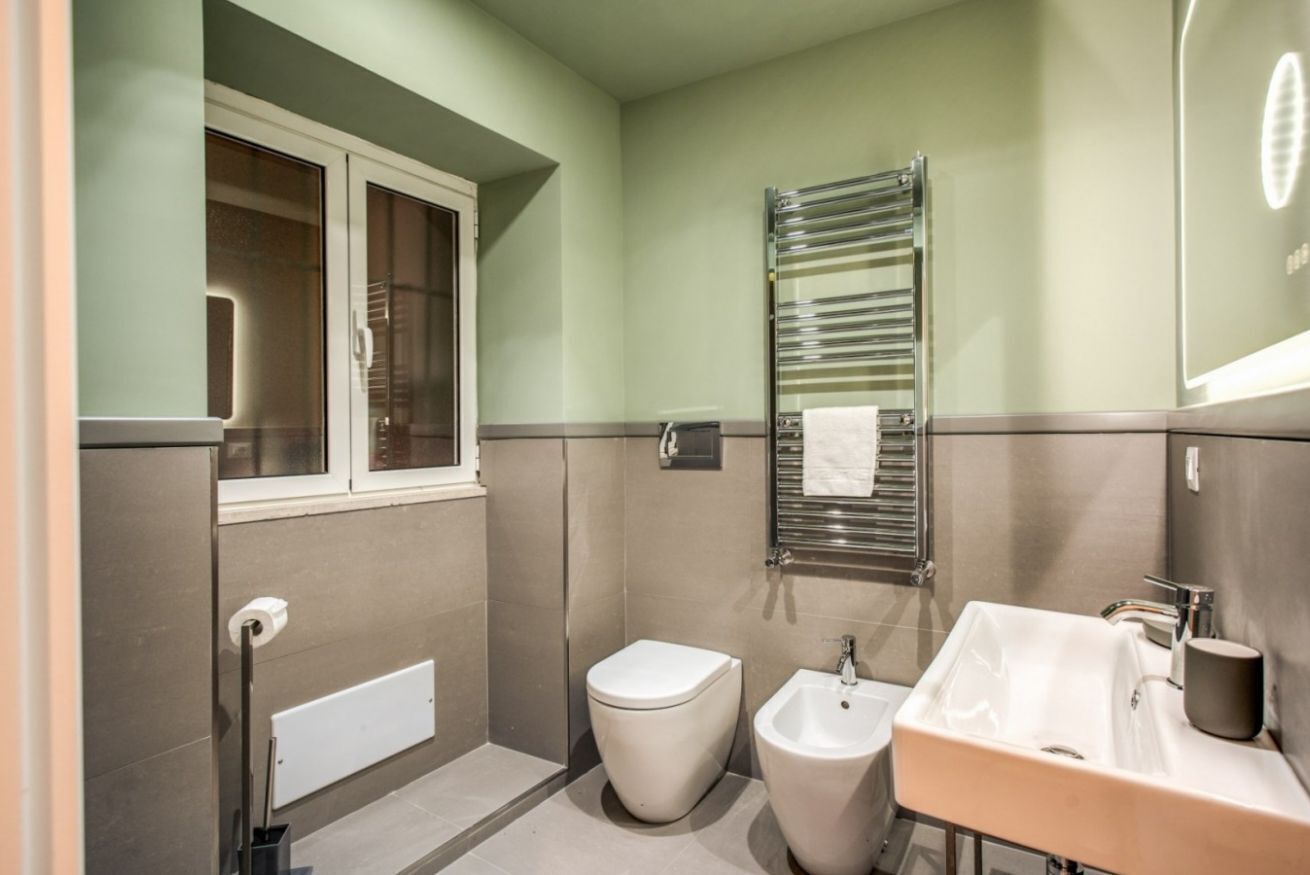 A compact bathroom with a toilet, bidet, and sink.