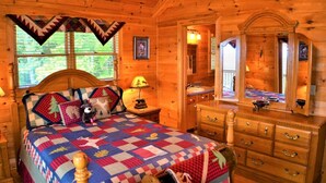 Une chambre dans une cabane en bois, avec un lit, une commode et un miroir.