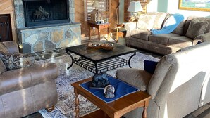 Un salón acogedor con chimenea de piedra, techo de madera y un sofá cómodo.