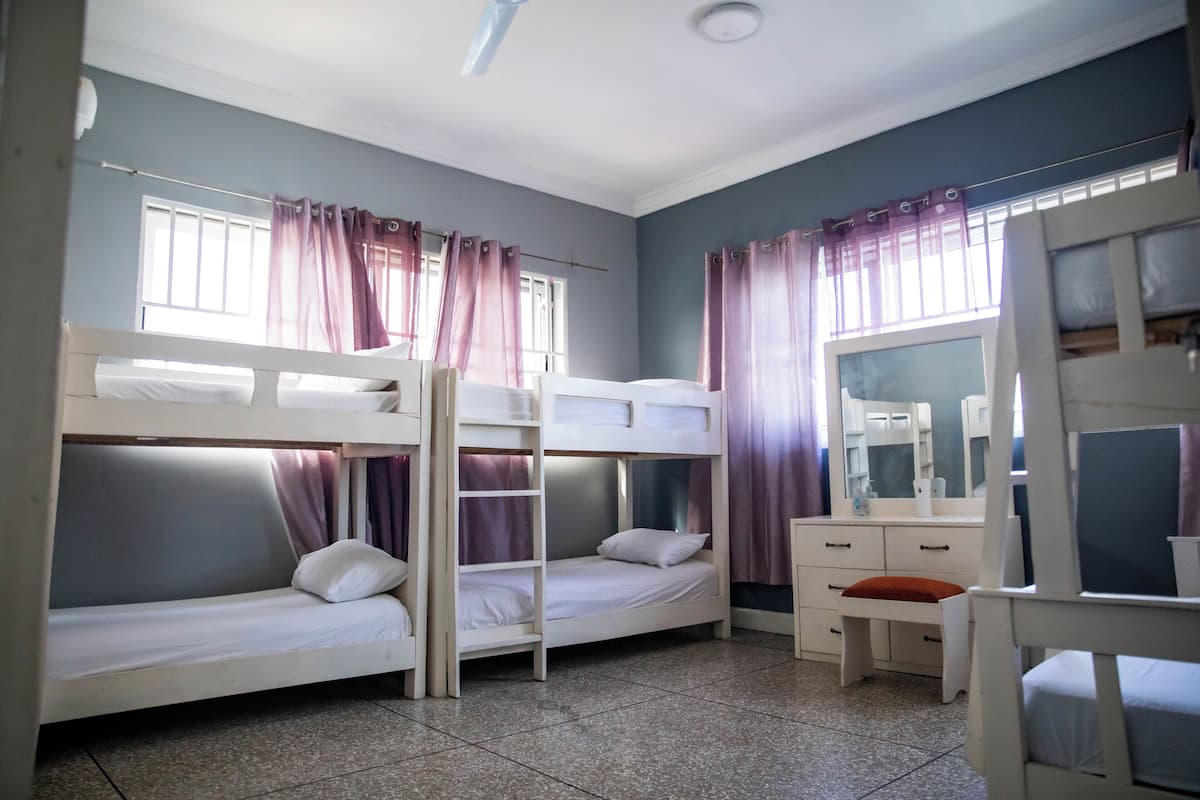 Quarto com beliche, escrivaninha e espelho.