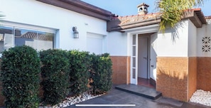 Stylish entrance with a covered porch and lantern, set amidst a beautifully manicured garden.