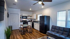 A modern apartment with a kitchen, dining area, and living room.