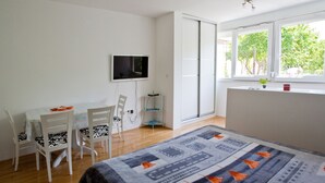 A bedroom with a bed, a desk, a chair, a TV, and a window. - 4* studio apartment, simple and modern in the beautiful city of Split (Split)