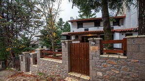 Un edificio con pareti in pietra, un cancello in legno, una scala in pietra e un cartello con la scritta "Chalet Iris".