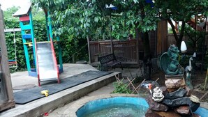 A stone pool with a dragon statue, a slide, and a wooden deck. - Private Odessa Apartment (Kryzhanivka)