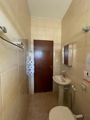 Une petite salle de bain avec des toilettes, un lavabo et une douche.