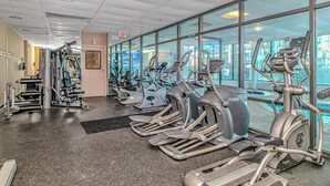 A gym with multiple treadmills, ellipticals, and weight machines. - The Palace 405 (Myrtle Beach)